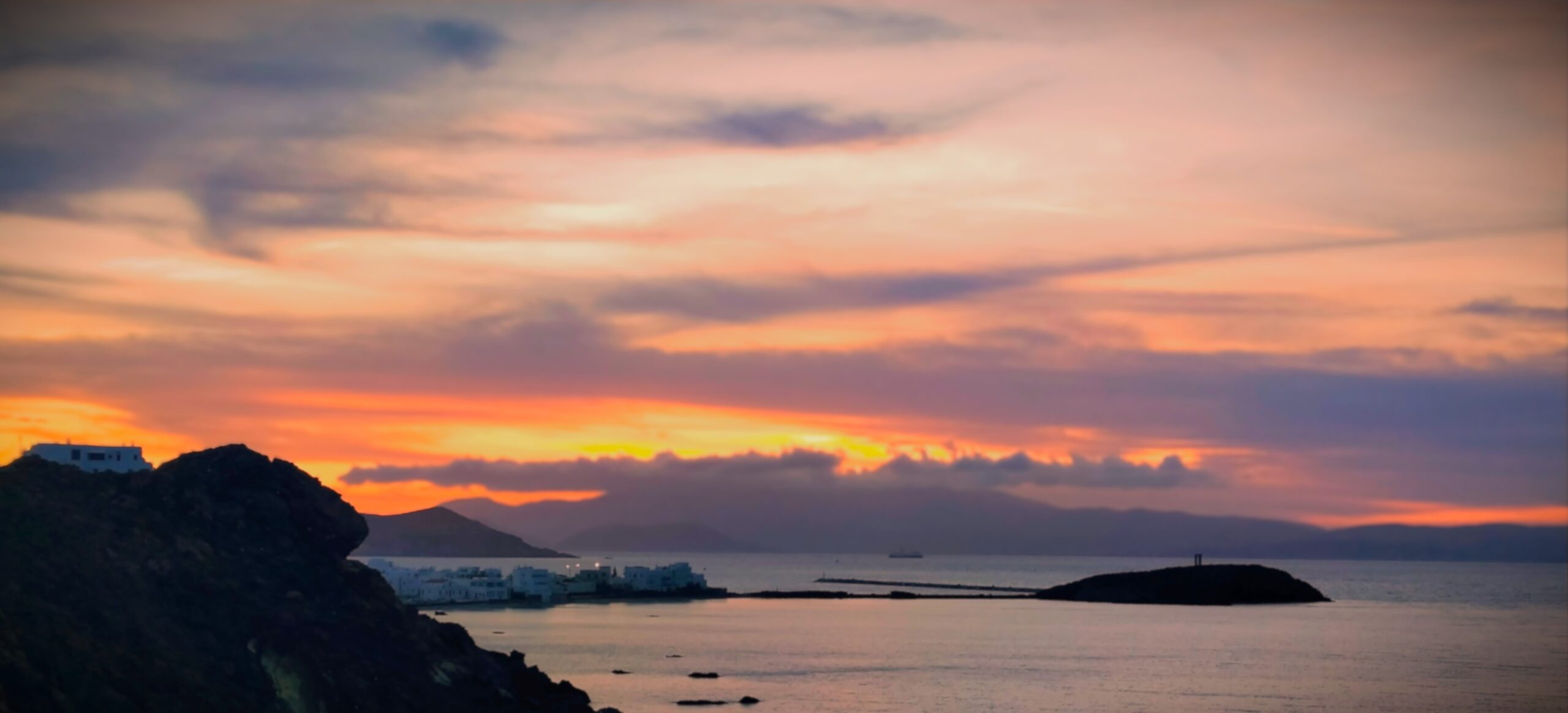 Car rental in Naxos with sunset view over Portara and Naxos Town, Greece